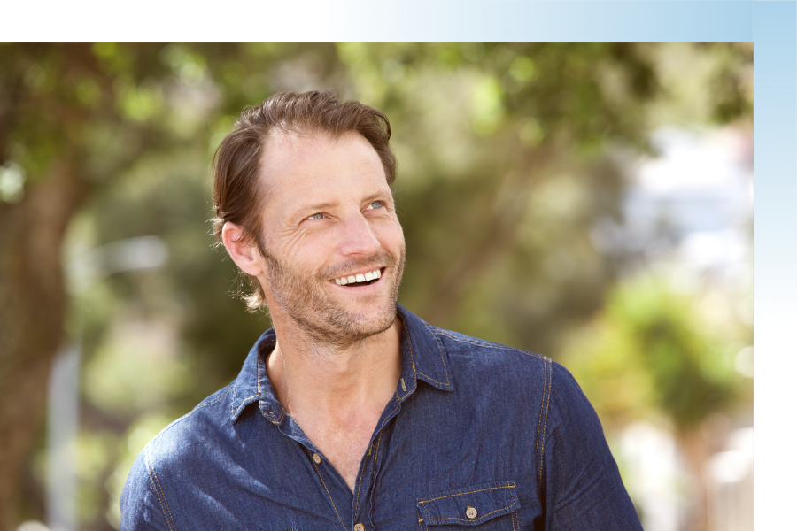 a man smiling as he looks off into the distance